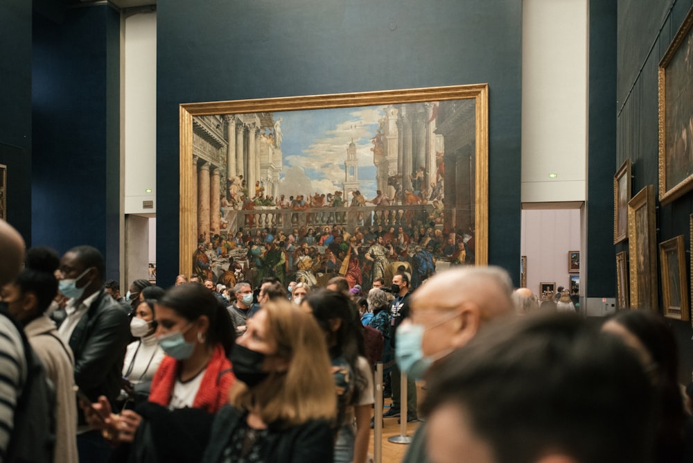 a group of people standing in front of a painting