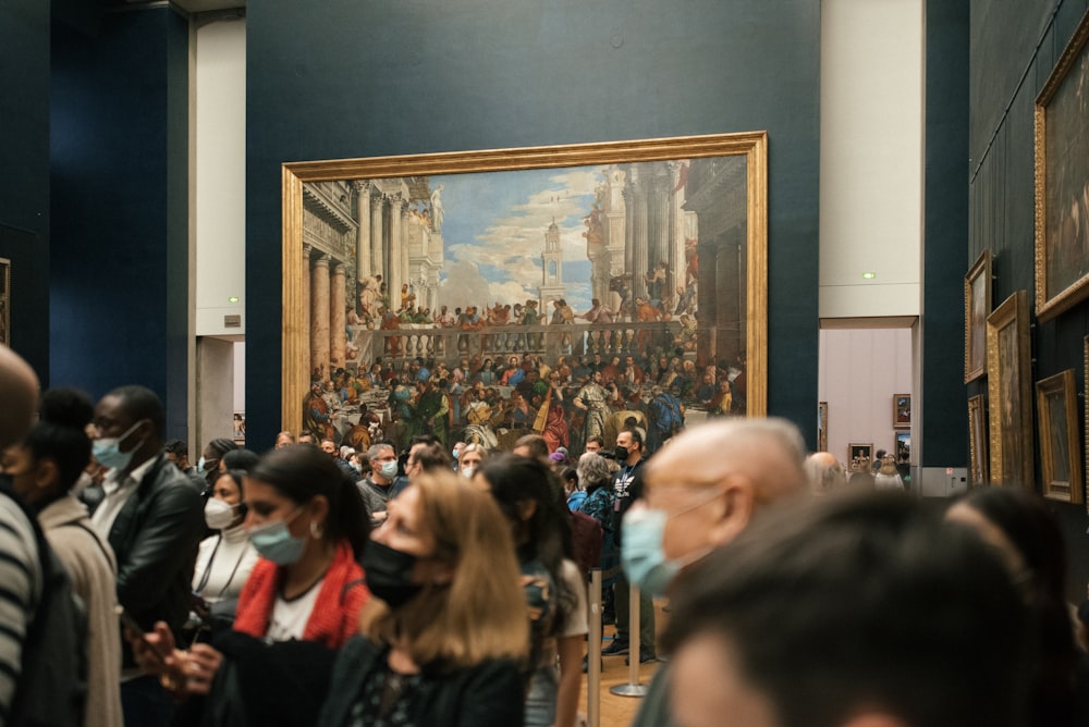 Un grupo de personas de pie frente a una pintura