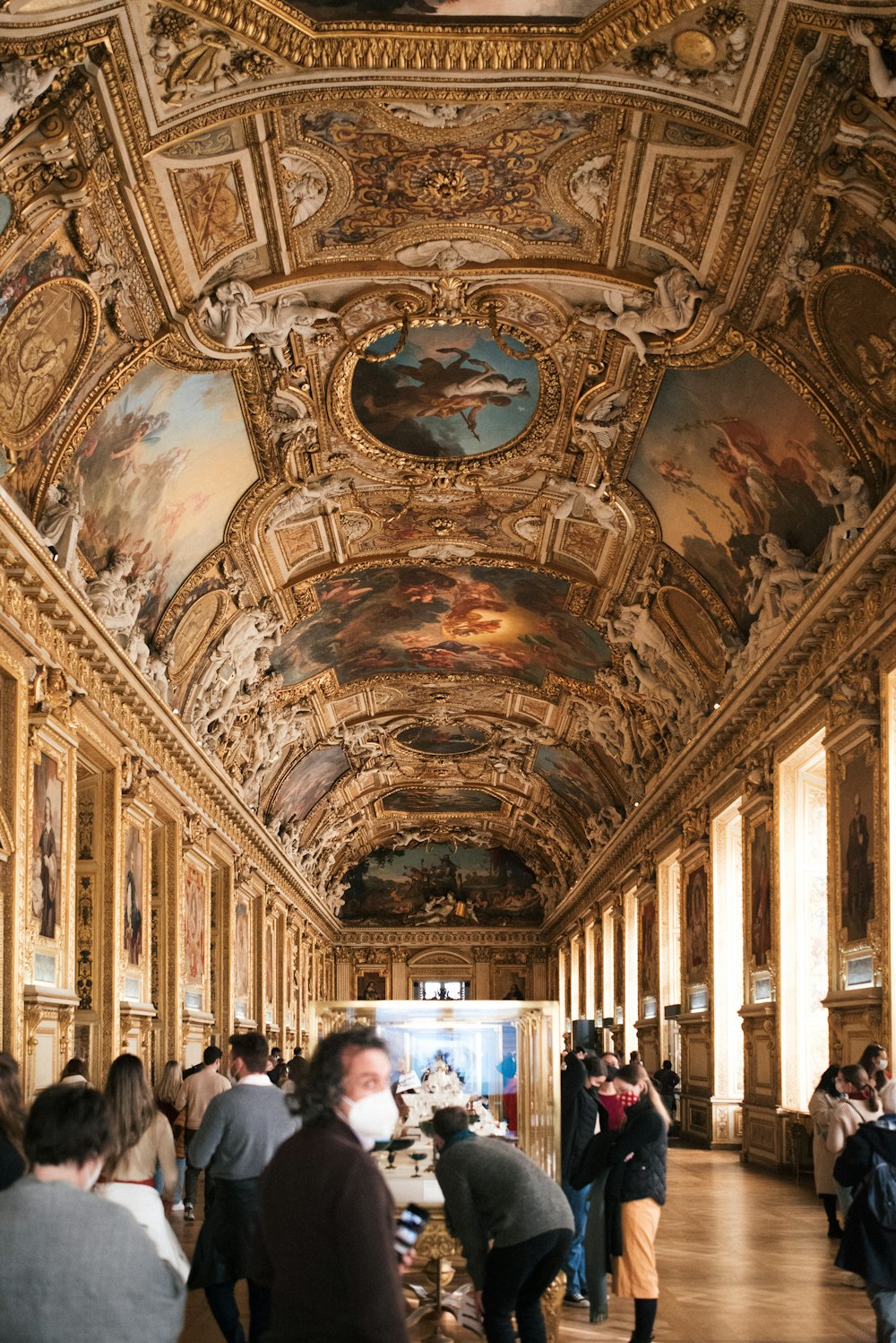 a group of people standing in a room with paintings on the walls