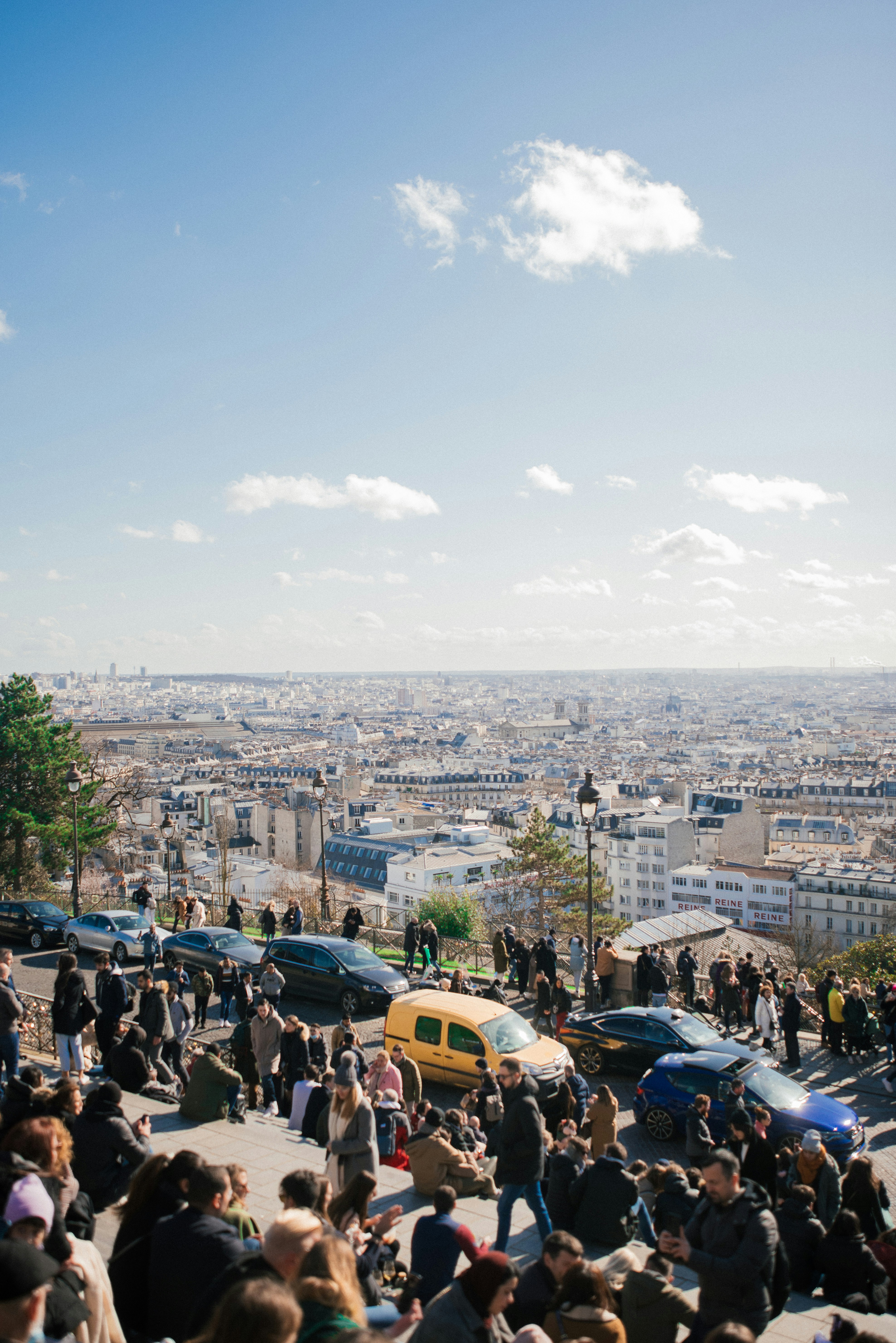 A crowd of people standing around a parking lot photo Free Parigi