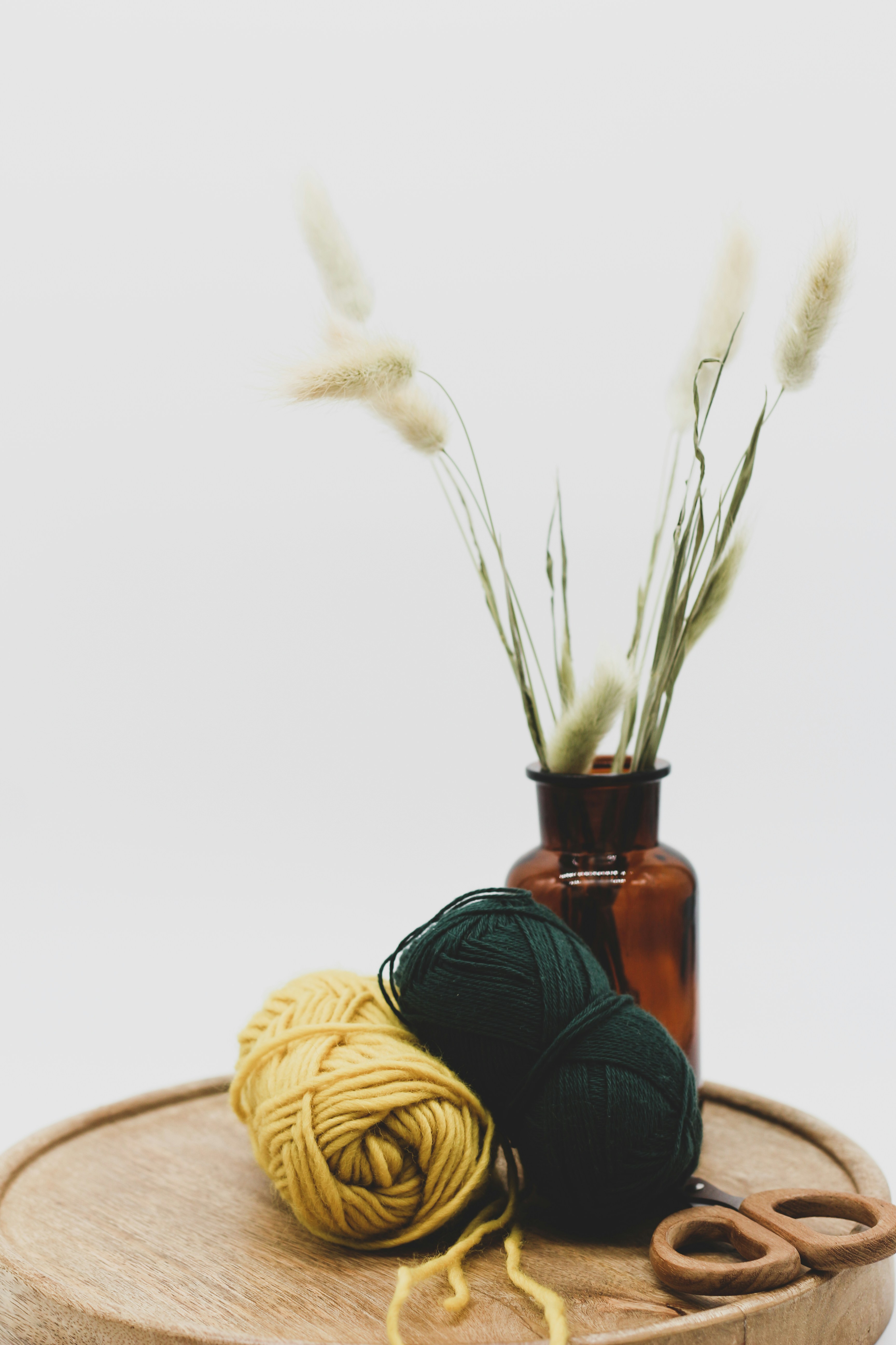 a wooden tray with yarn and scissors on it