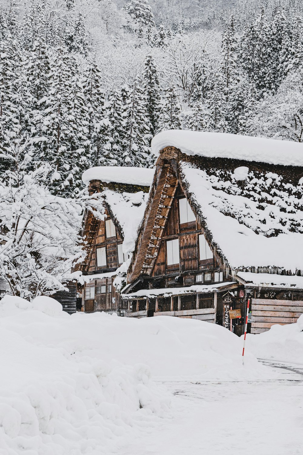 eine schneebedeckte Skihütte mit Bäumen im Hintergrund