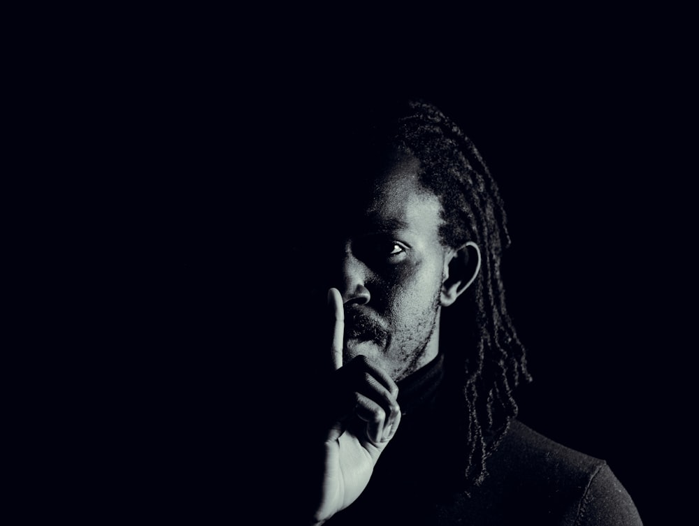 a man with dreadlocks holding his hand to his face