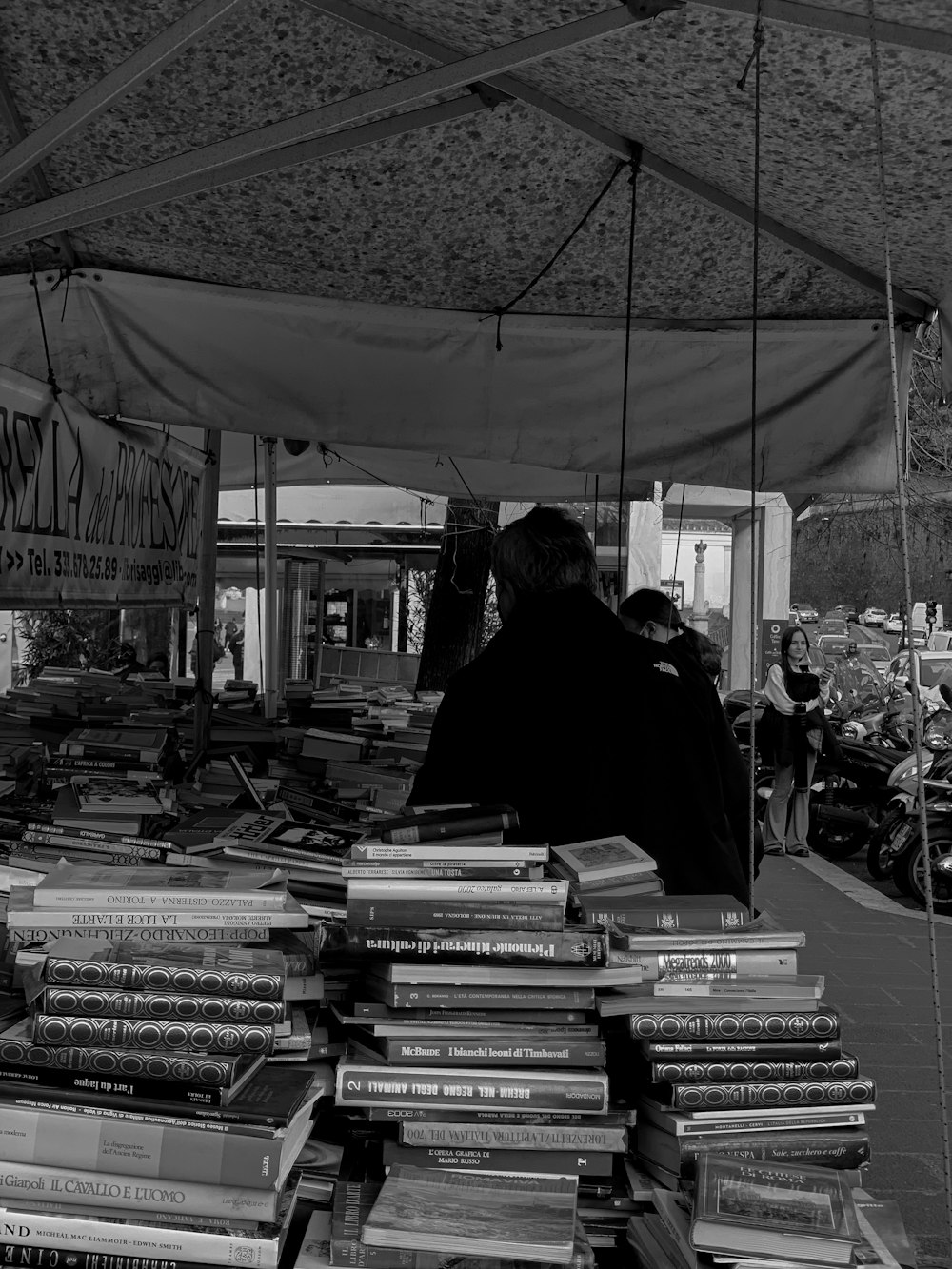 a man is looking at a large pile of books
