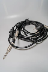 Various audio cables and connectors neatly coiled and organized on a wooden table.