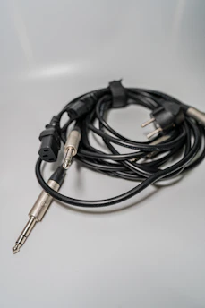 Various car audio cables and plug-and-play connectors neatly arranged on a white surface with light green highlights.