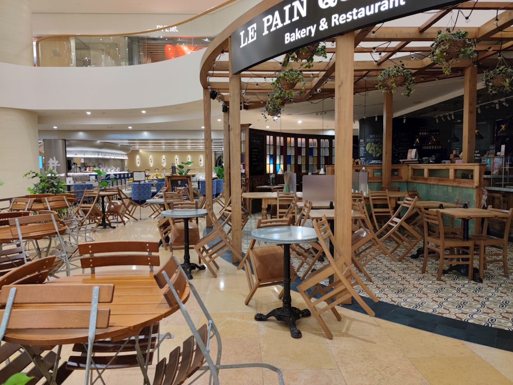 a restaurant filled with lots of wooden tables and chairs