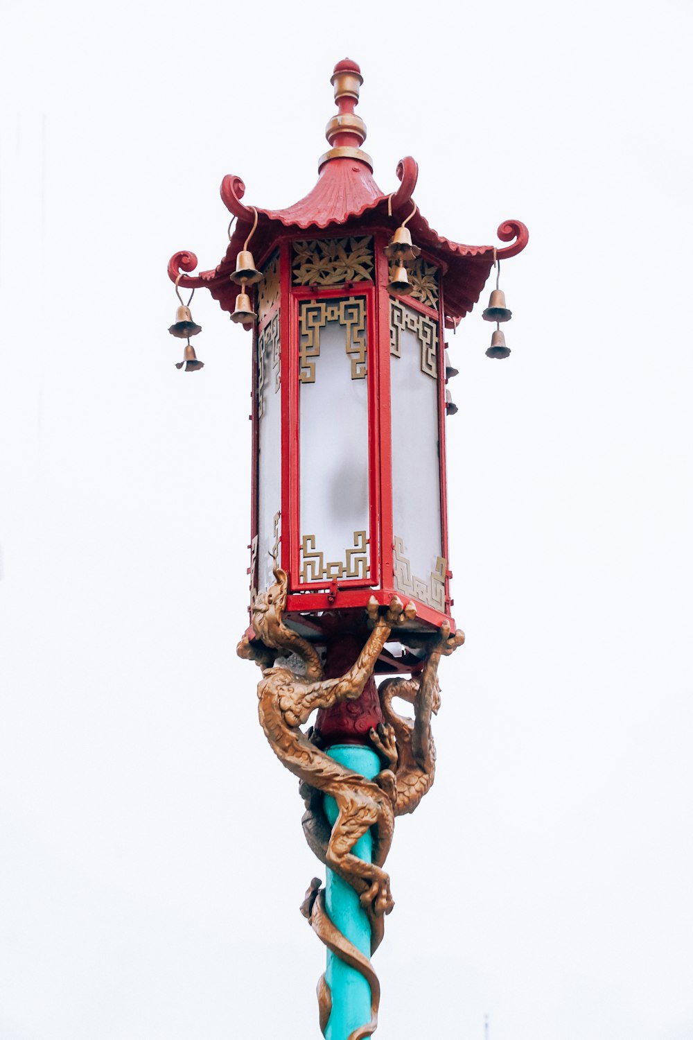 a red lamp post with a mirror on top of it