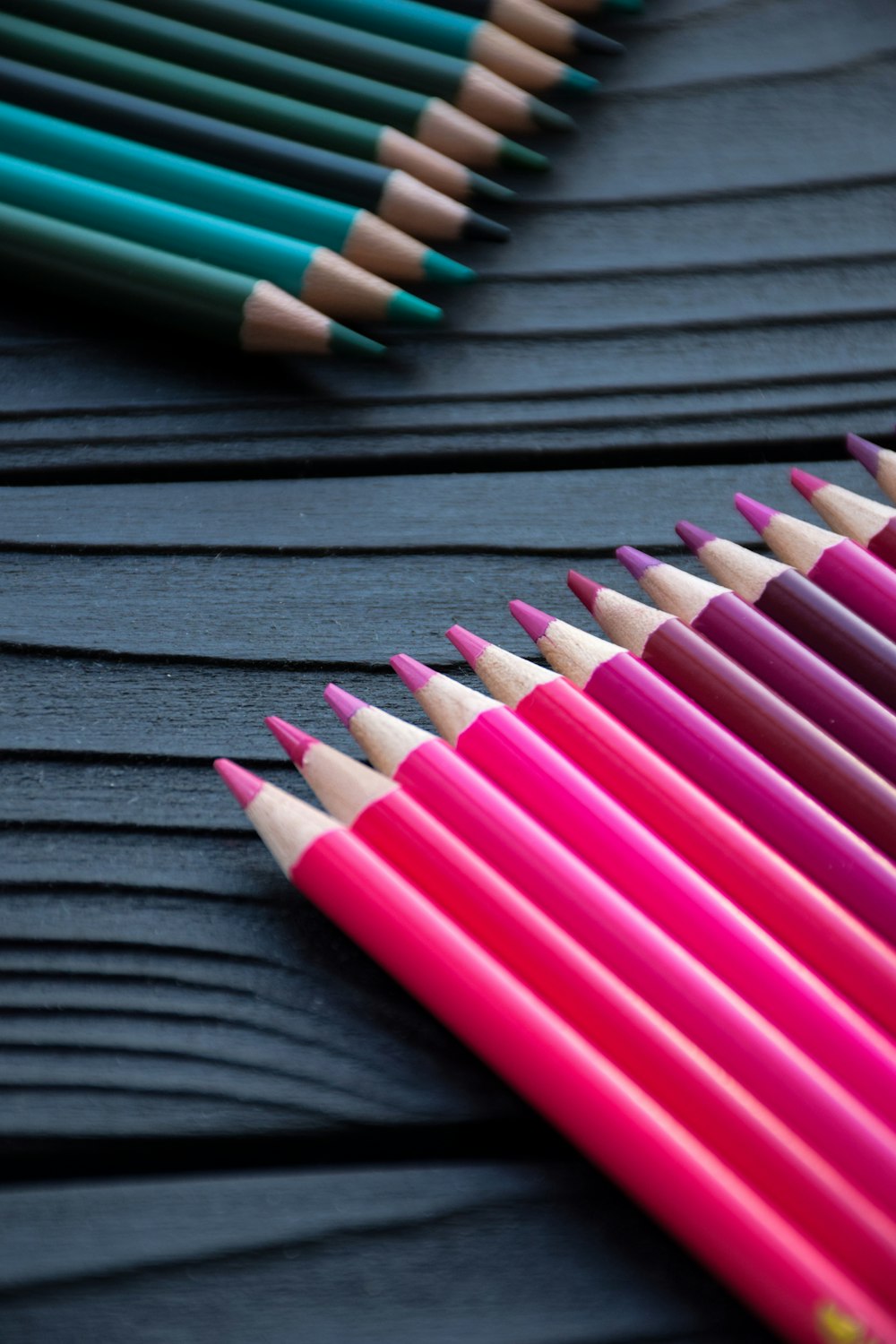 a row of colored pencils sitting on top of a table