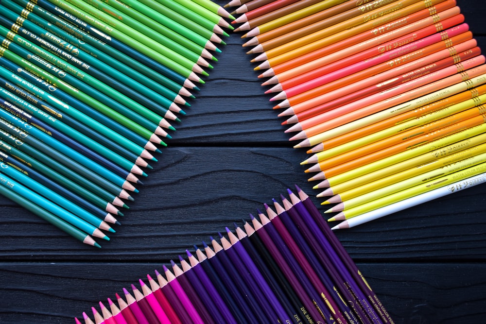 a group of colored pencils sitting on top of a table