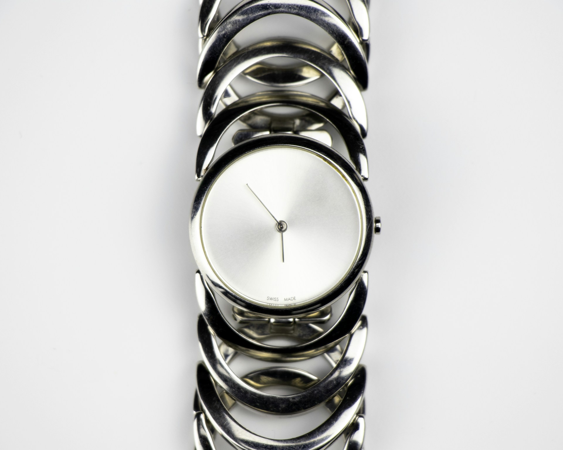 a silver watch with a white face on a white background