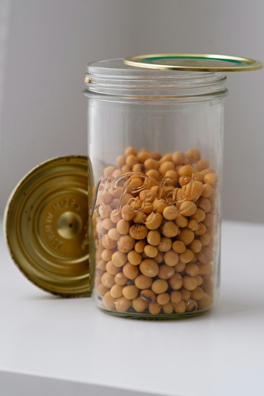 a glass jar filled with yellow and brown beans