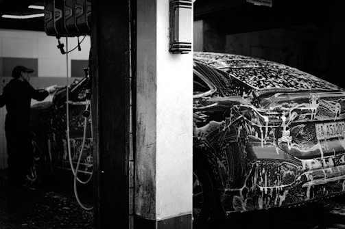 a man washing a car in a garage