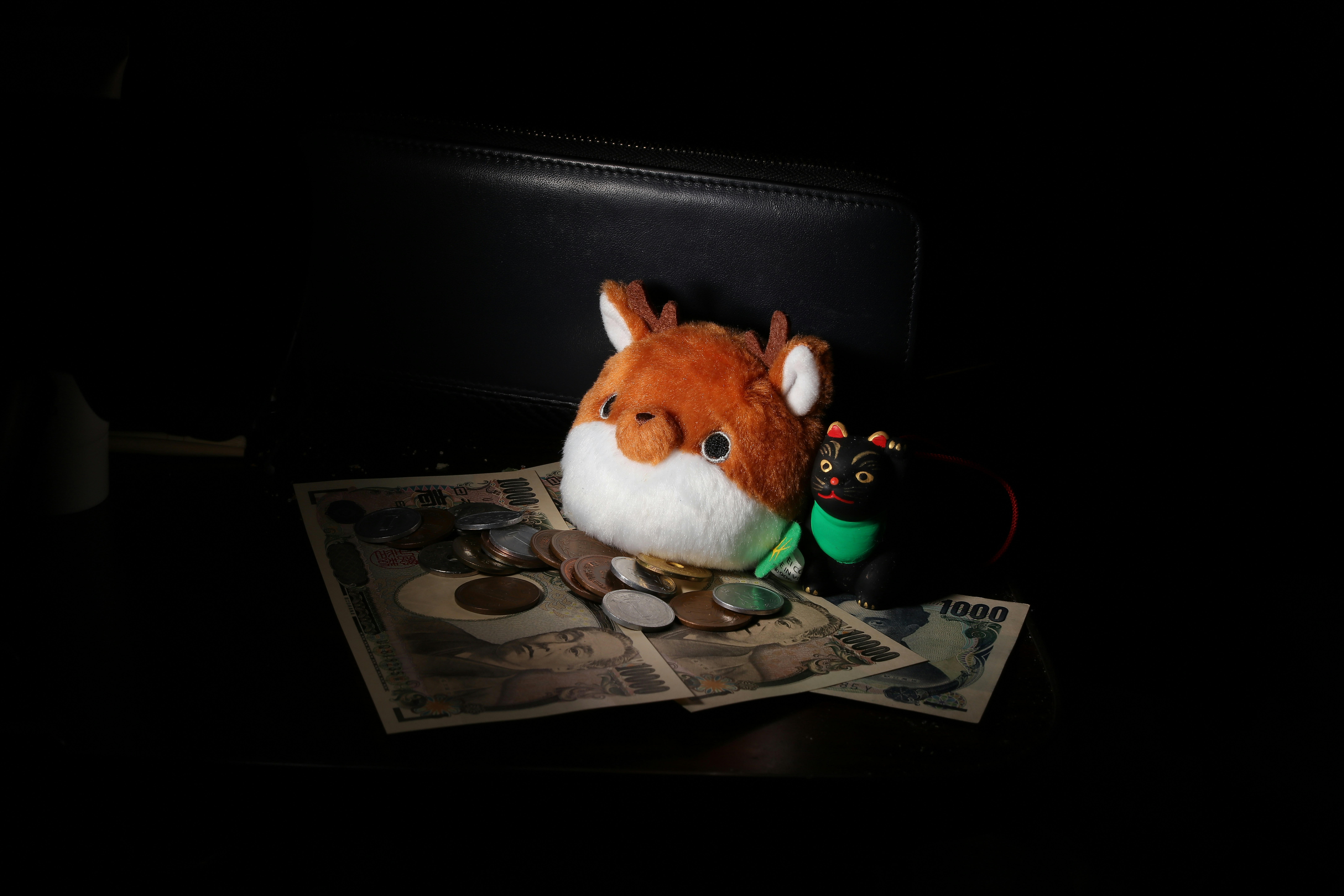 a stuffed animal sitting on top of a pile of money
