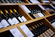a bunch of wine bottles that are on a shelf