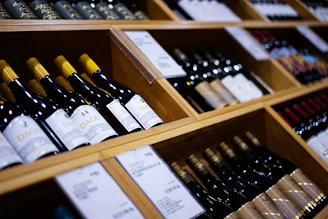 a bunch of wine bottles that are on a shelf