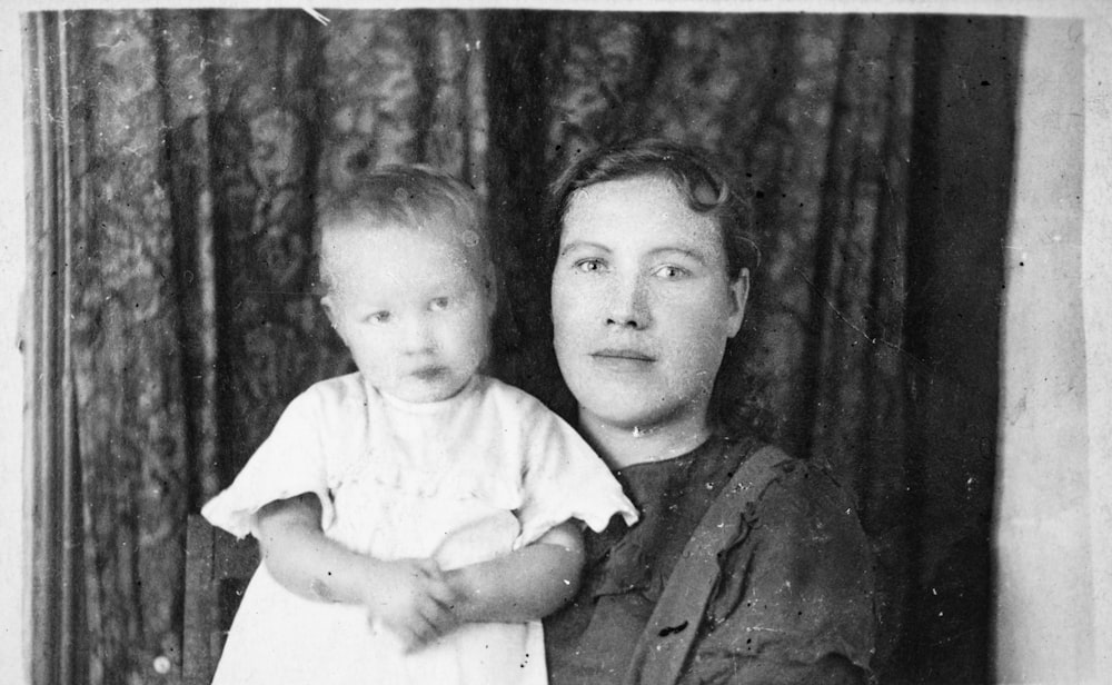 Ein Schwarz-Weiß-Foto einer Frau, die ein Baby hält