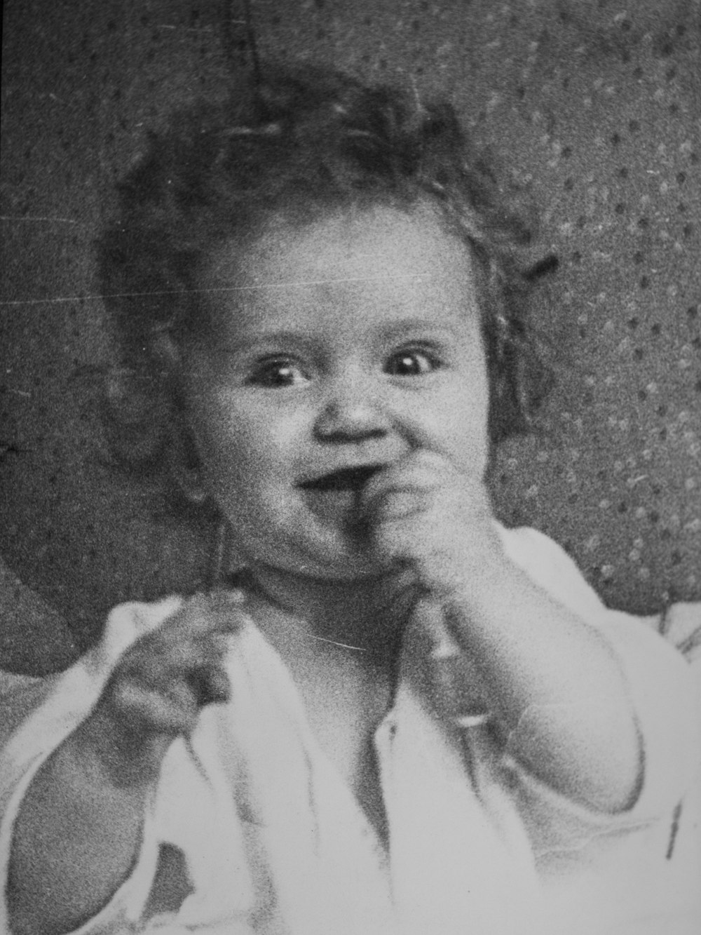 une photo en noir et blanc d’une petite fille mangeant quelque chose