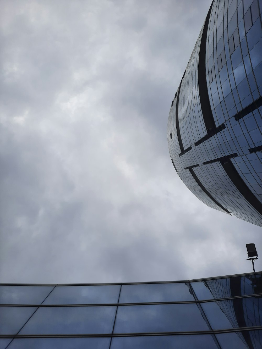 a very tall building next to a very cloudy sky