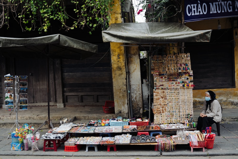 a woman sitting on a bench in front of a store