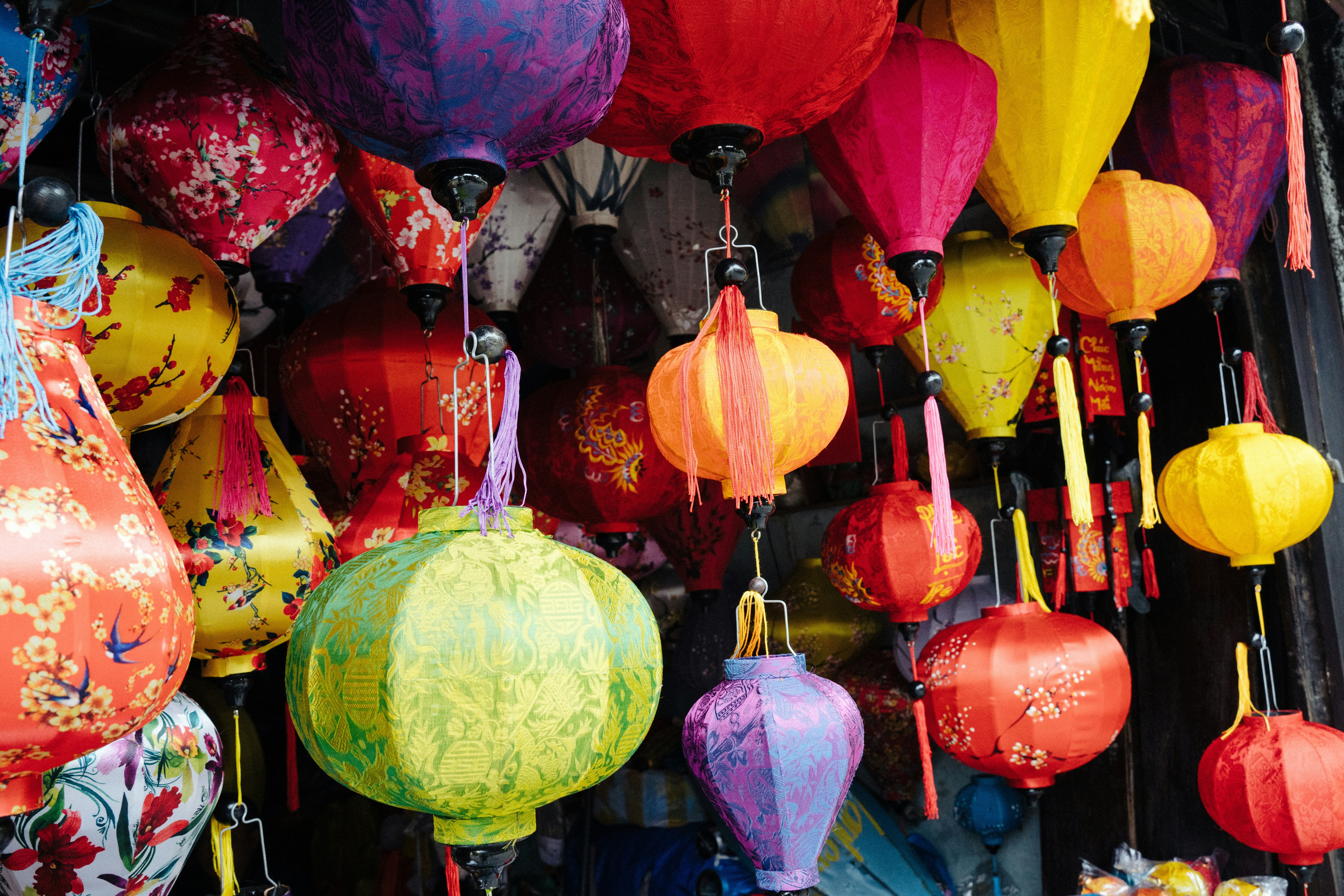 A bunch of colorful paper lanterns hanging from a ceiling photo – Free