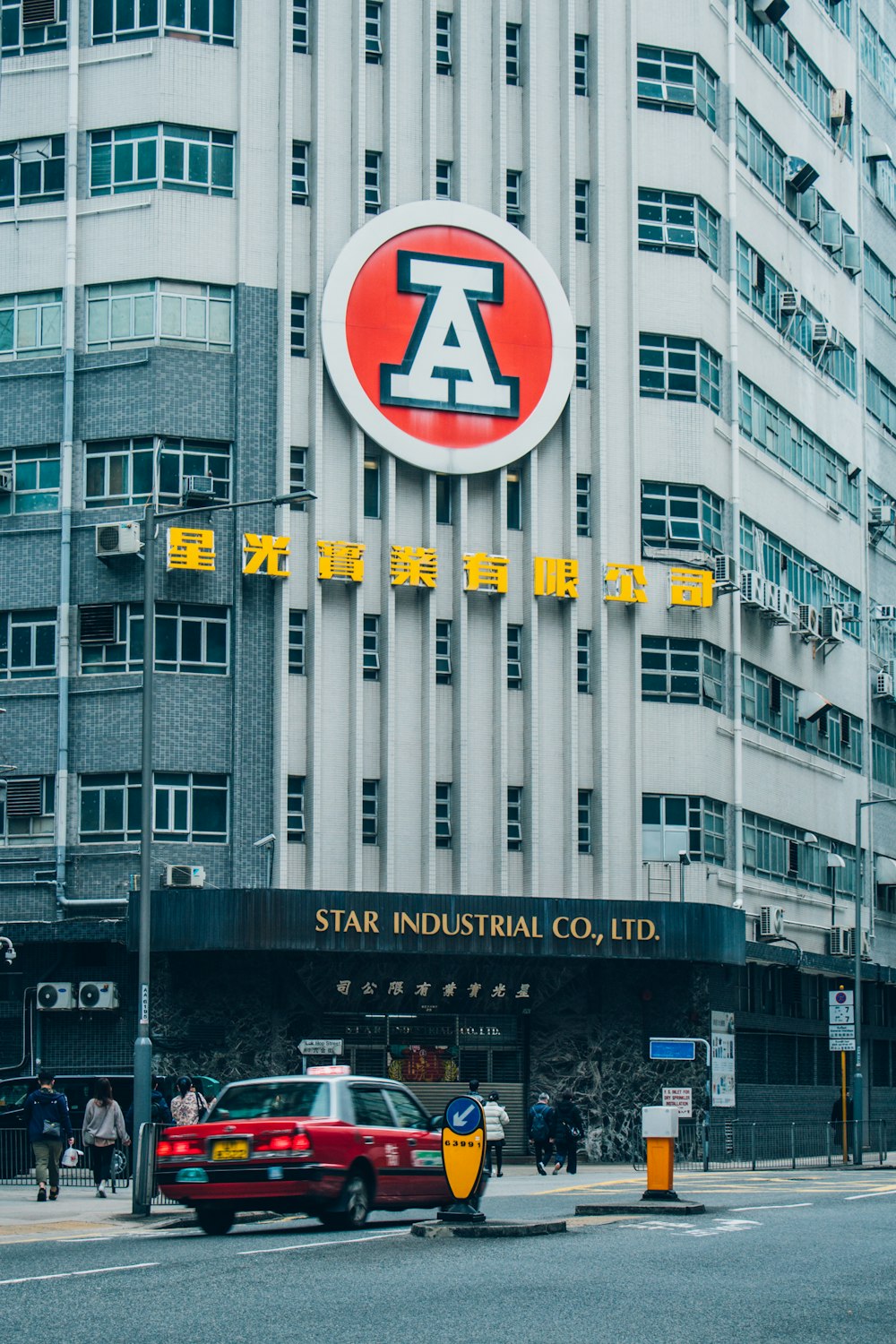 a red car parked in front of a tall building