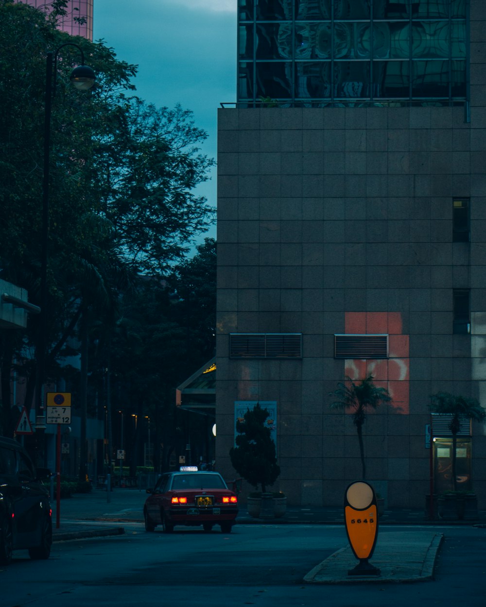 a car driving down a street next to a tall building