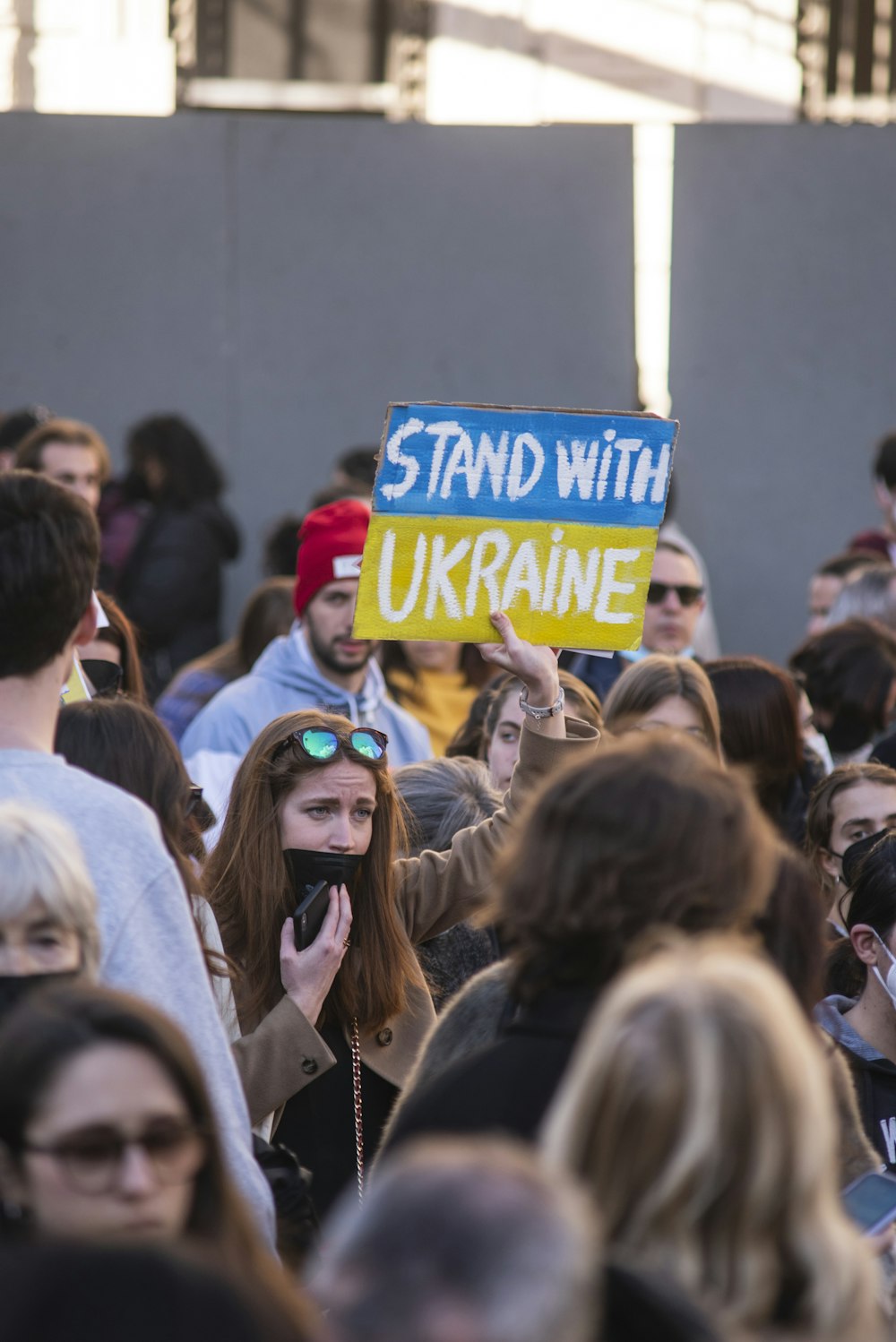 a crowd of people standing around each other holding signs