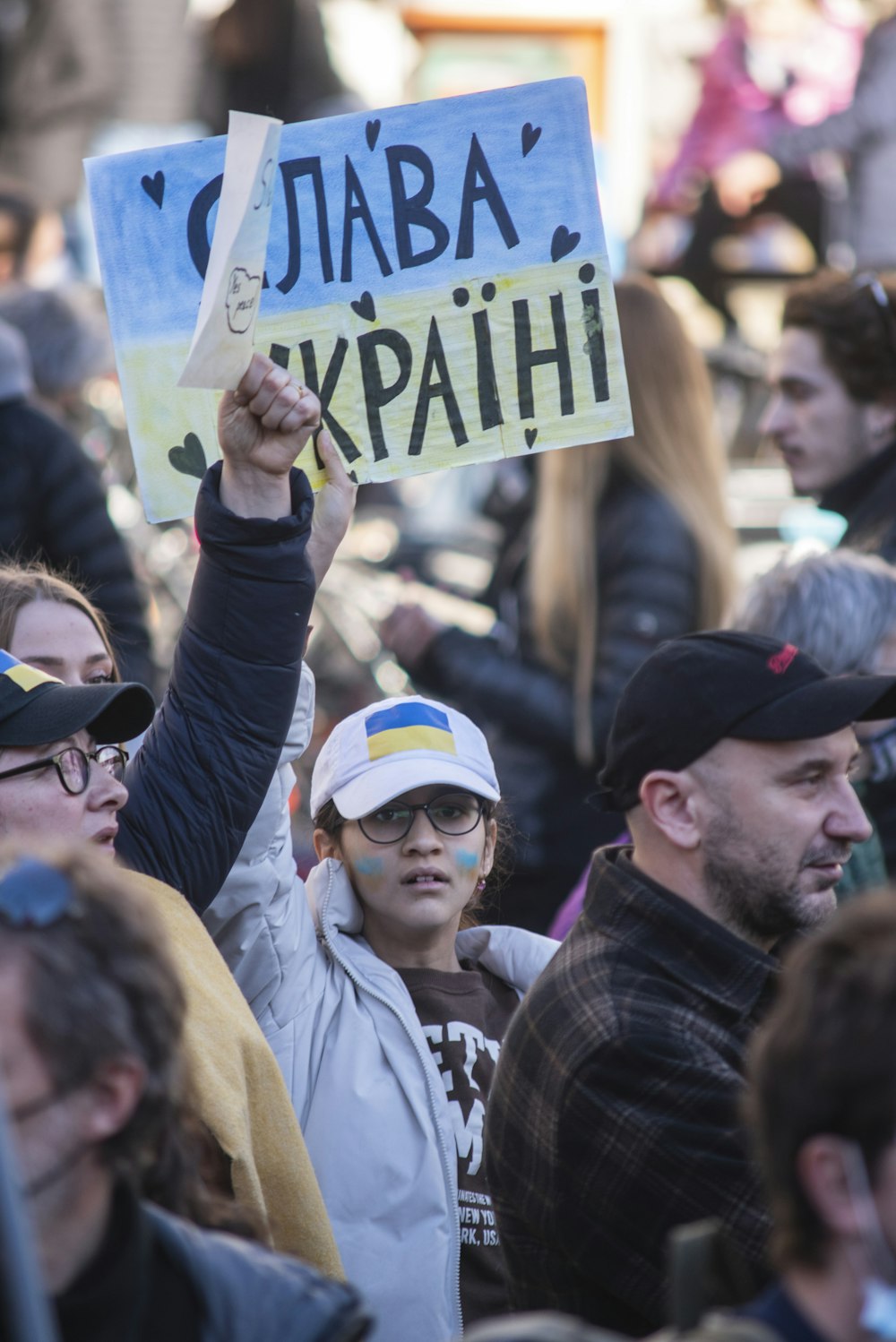 a group of people standing around each other holding signs