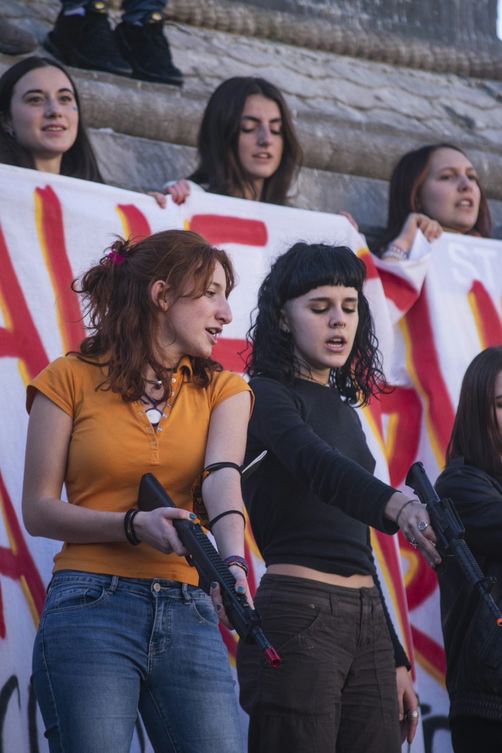 a group of women holding guns in front of a crowd