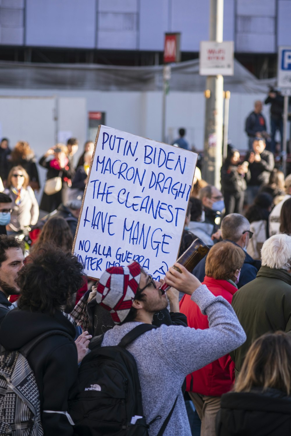 a crowd of people standing around each other holding signs