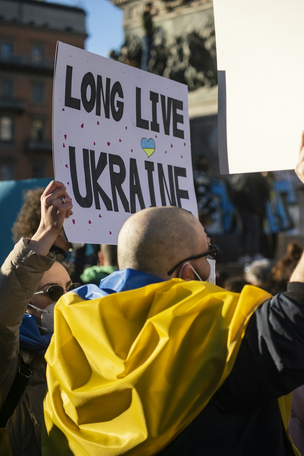 a group of people holding up a sign that says long live ukraine