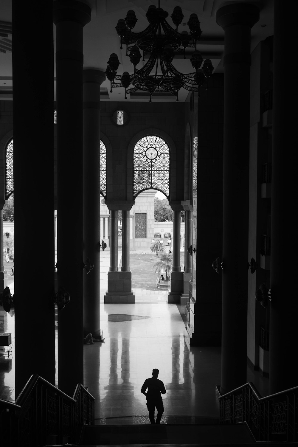 a black and white photo of a person walking down a hall