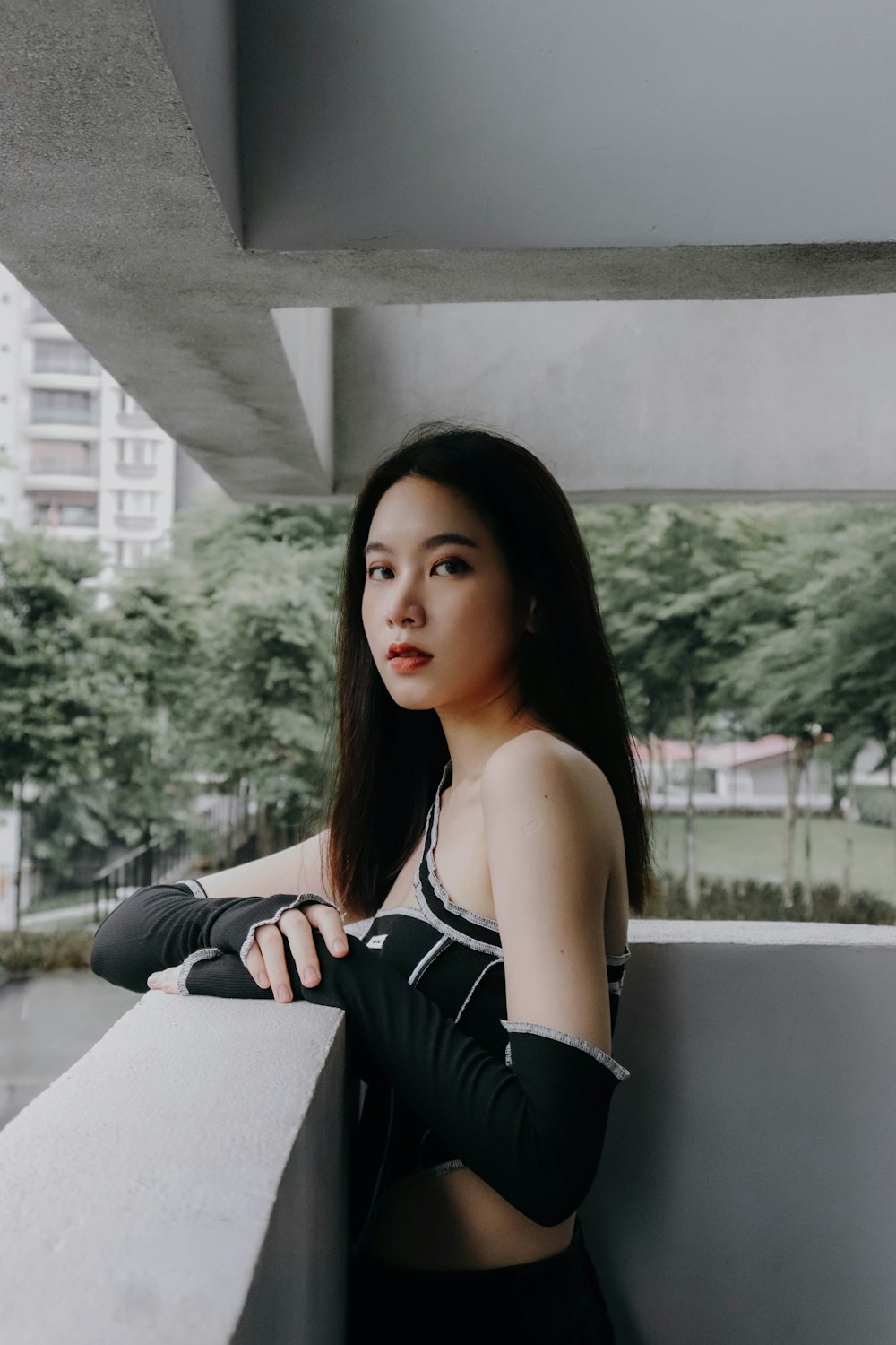 a woman in a sports bra top leaning against a wall