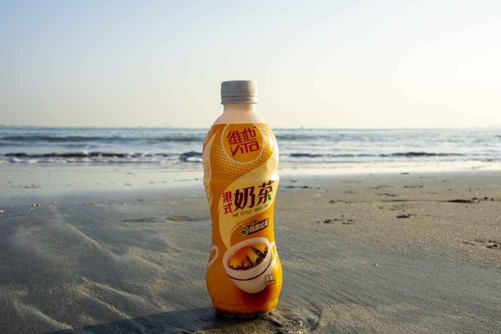 a bottle of sunflower oil sitting on a beach