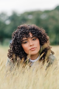 a woman laying in a field of tall grass