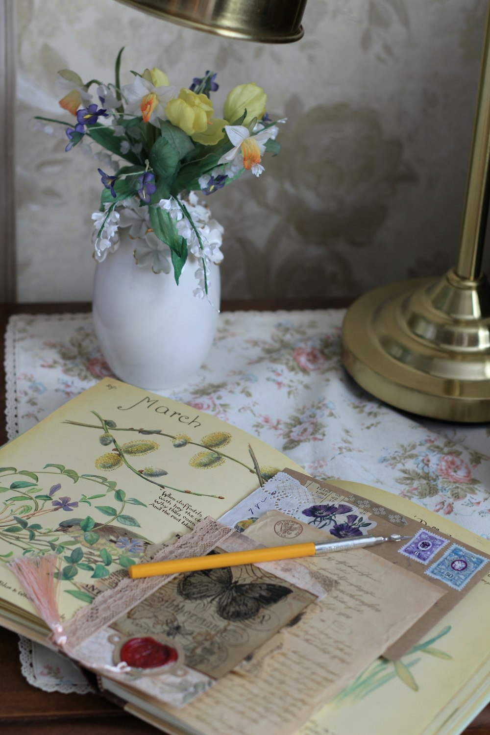 a vase of flowers sitting on top of a table next to an open book