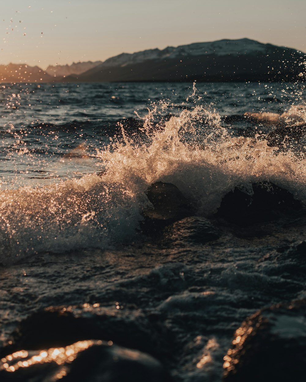 a wave hitting on rocks in the ocean