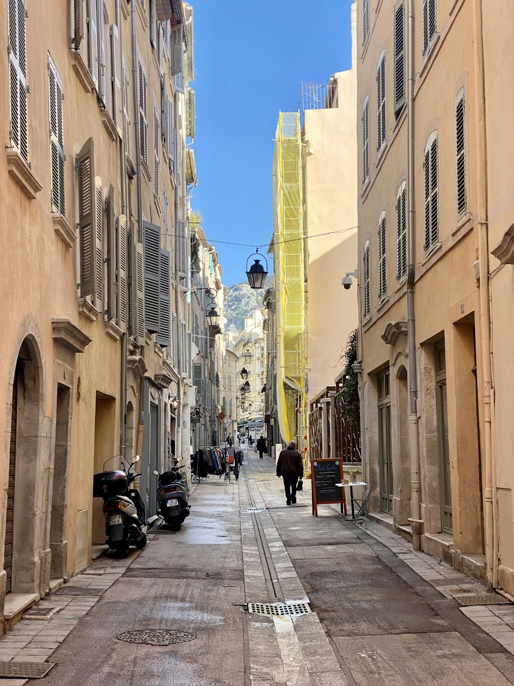 a narrow city street lined with tall buildings