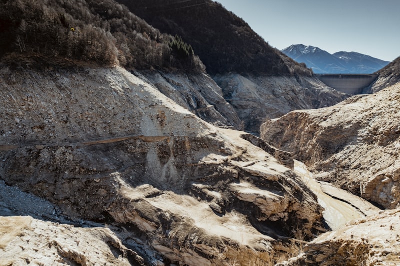 A dried-out reservoir bed with exposed sediment and low water levels