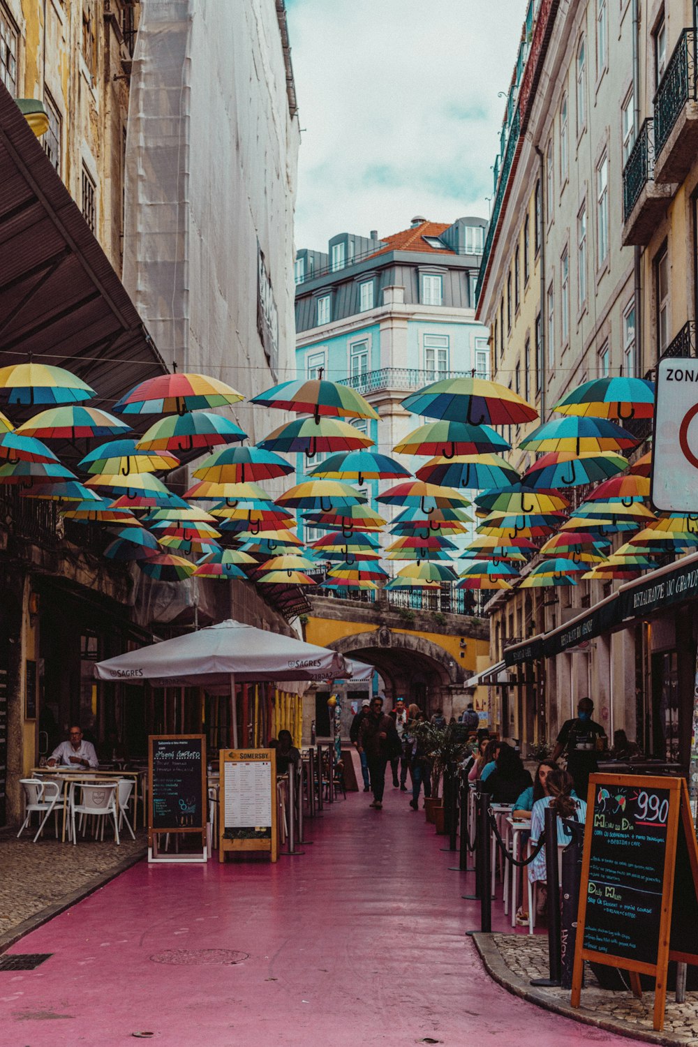 a group of people walking down a street under umbrellas