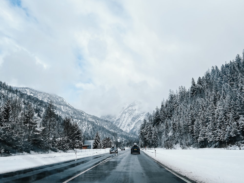 a car driving down a snowy road in the mountains