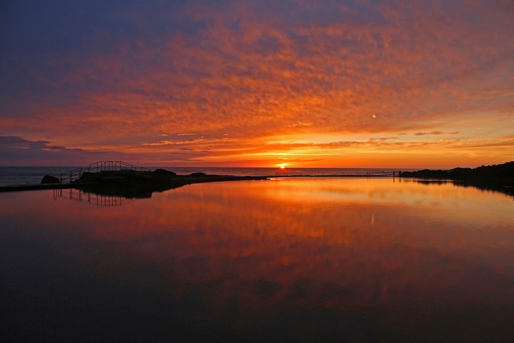 the sun is setting over a body of water