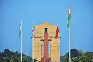 a clock tower with flags flying in front of it