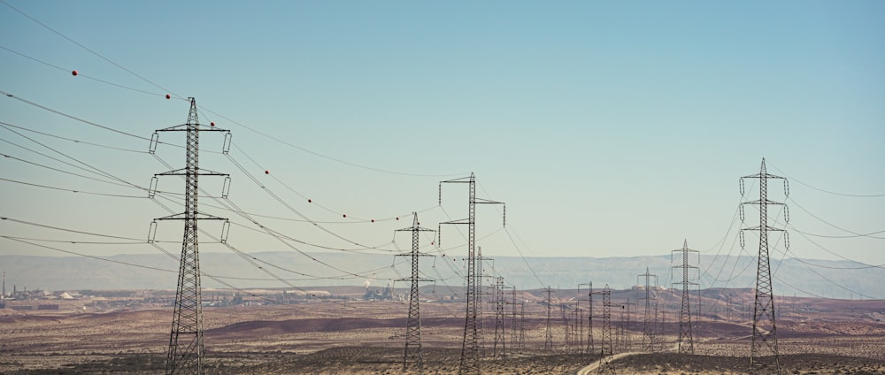 a group of power lines in the middle of a desert