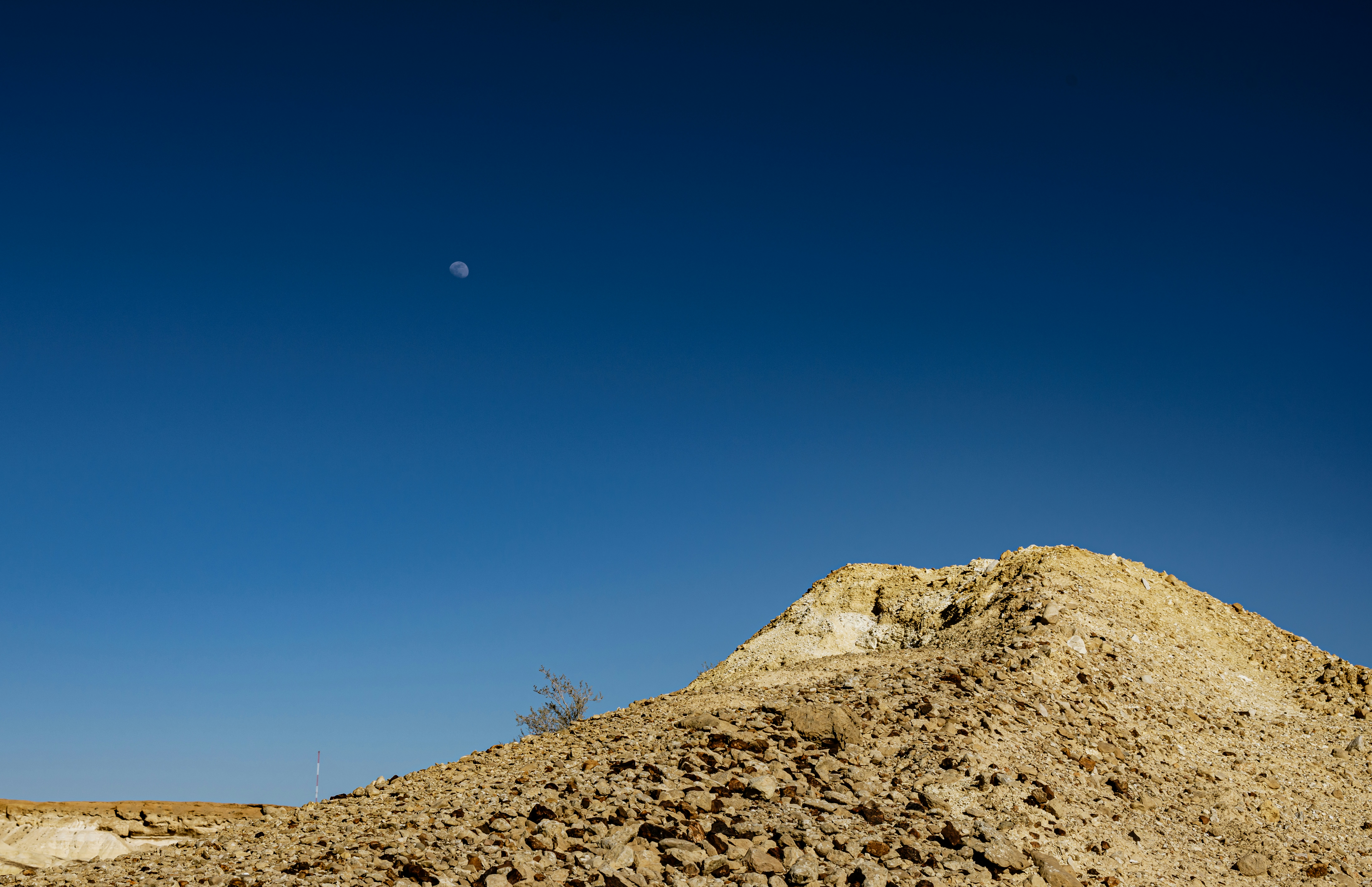 a hill of dirt with a moon in the sky