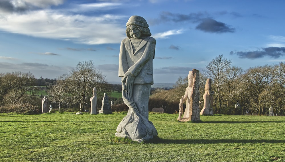 a statue of a woman standing in a field