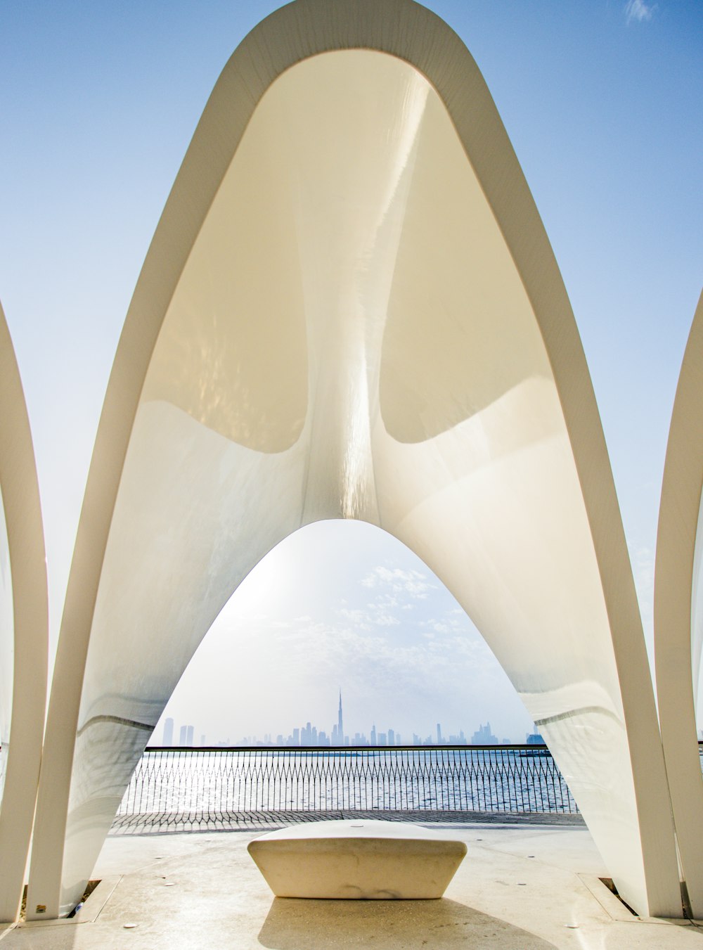 une grande sculpture blanche assise à côté d’un plan d’eau