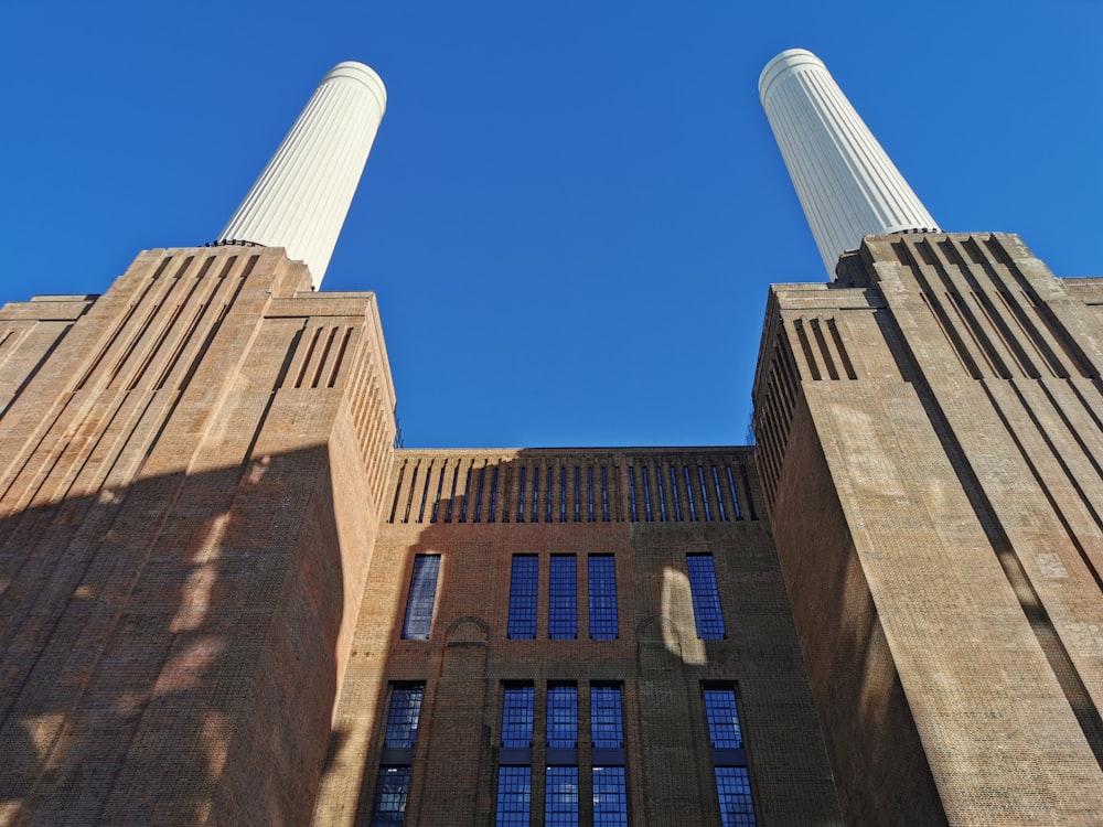 two tall brick buildings with windows and a sky background