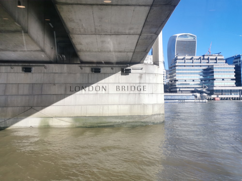 a bridge over a body of water with a building in the background